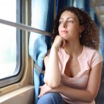 ženska na vlaku gleda skozi okno