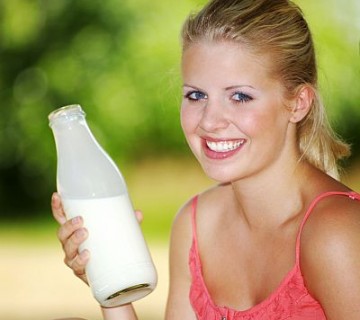 ženska s steklenico mleka iz mlekomata