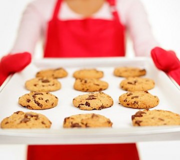 piškoti izmenjava piškoti na pekaču, ki ga drži ženska